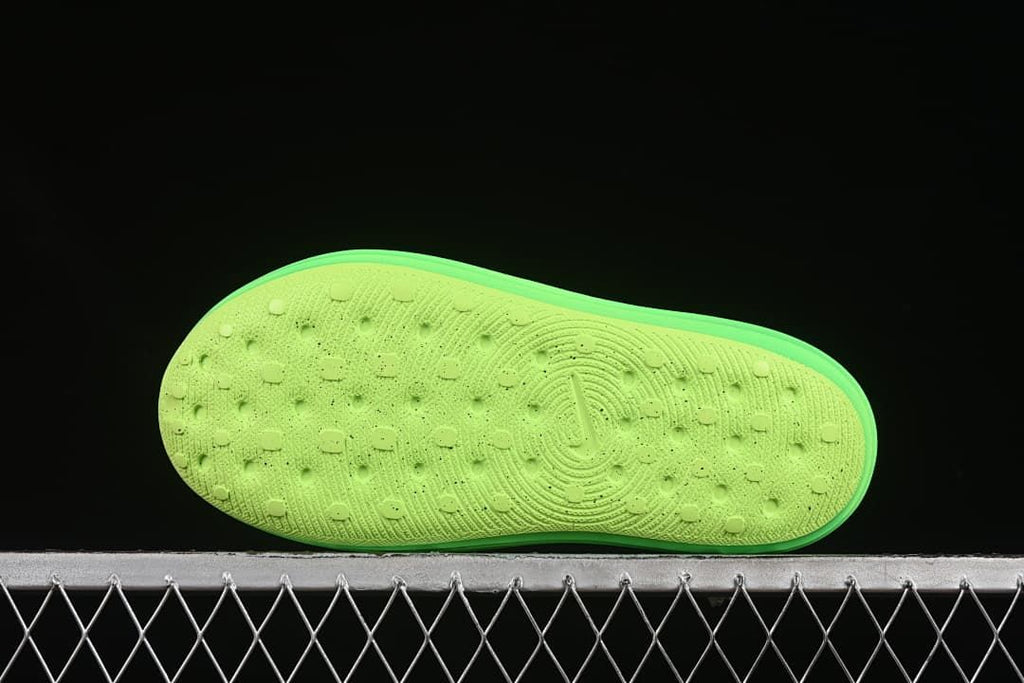 Underside of the green clog showing the textured outsole.