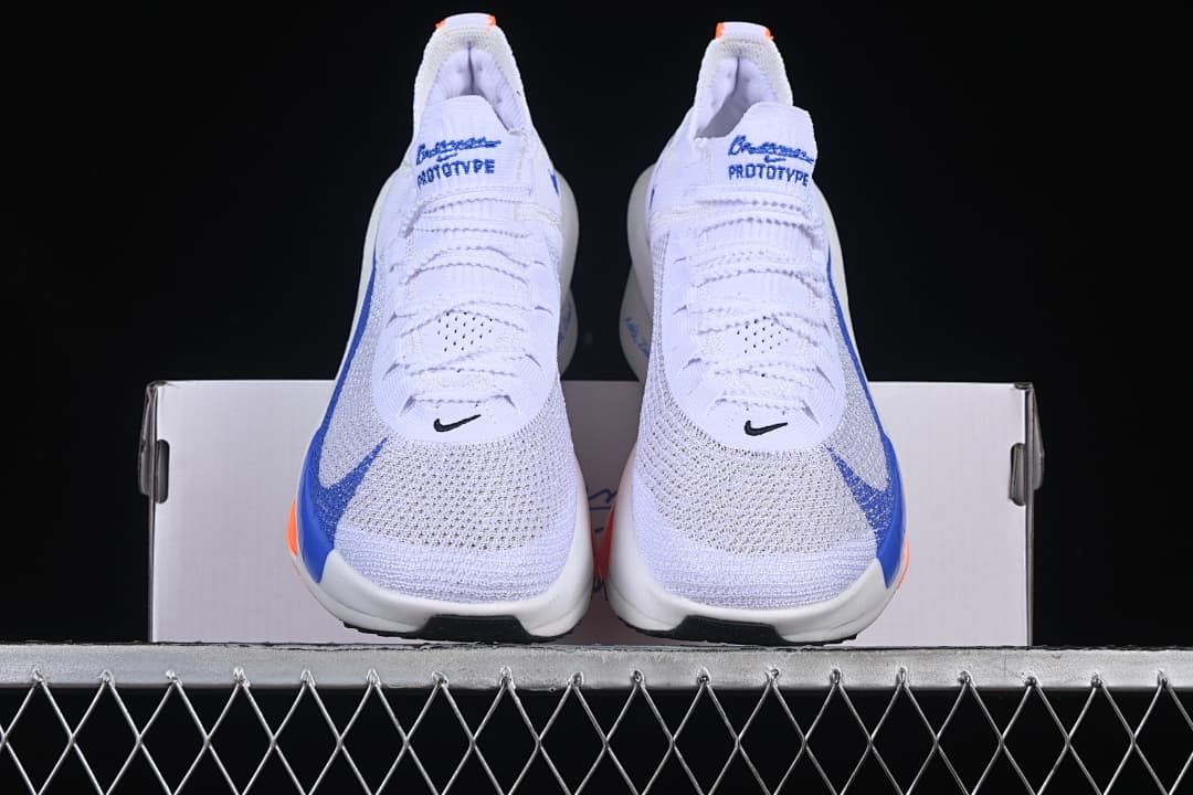 Front view of the pair showing white uppers, blue accents and orange details.