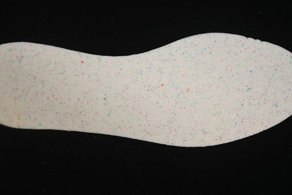 Close-up of a light-colored insole with multicolor speckled details.