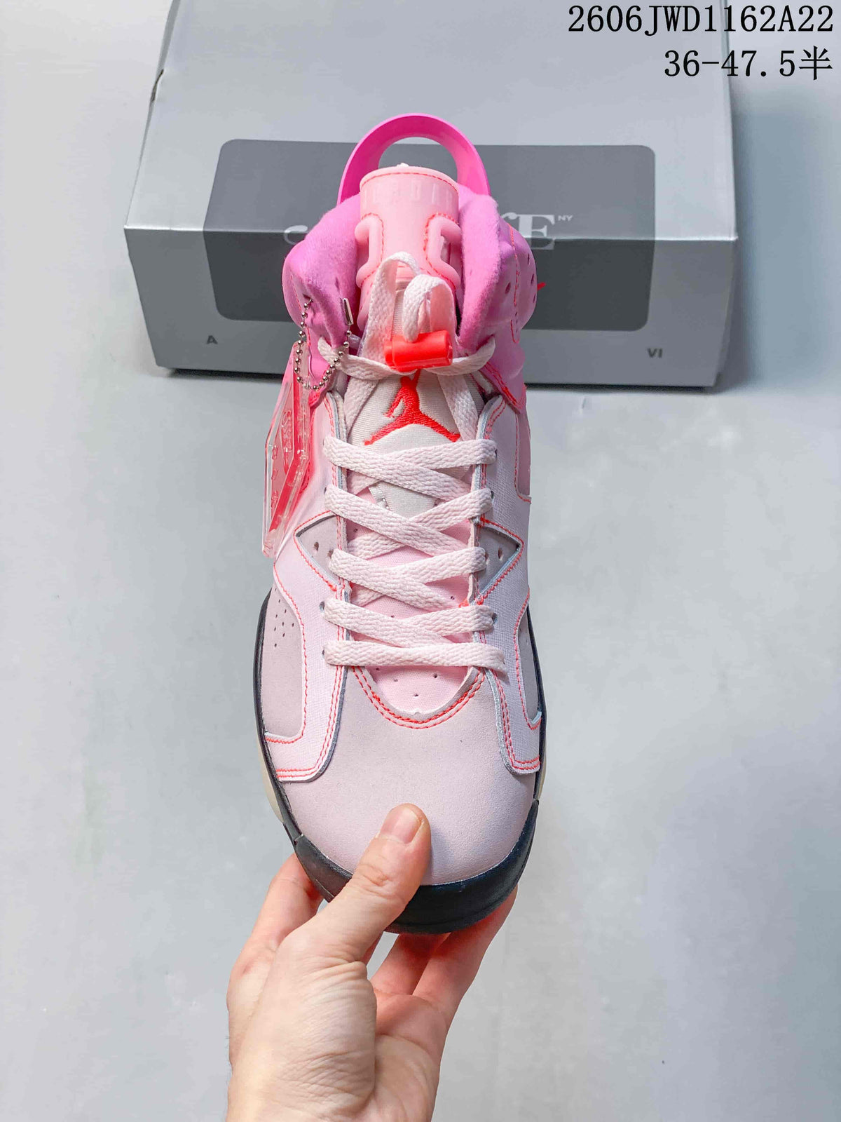 Front view of the pink Air Jordan 6 with white laces and a lace toggle