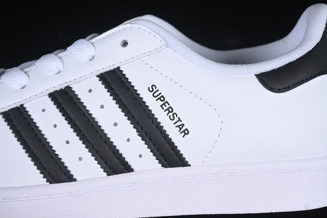 Close-up of black three-stripe side details and Superstar lettering
