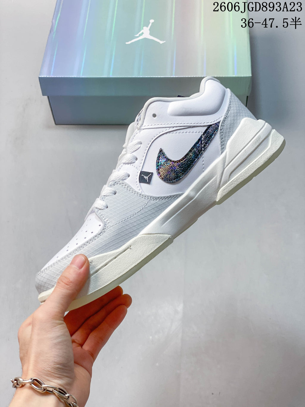 Side profile of a white and grey Jordan Stadium 90 sneaker with an iridescent Swoosh.
