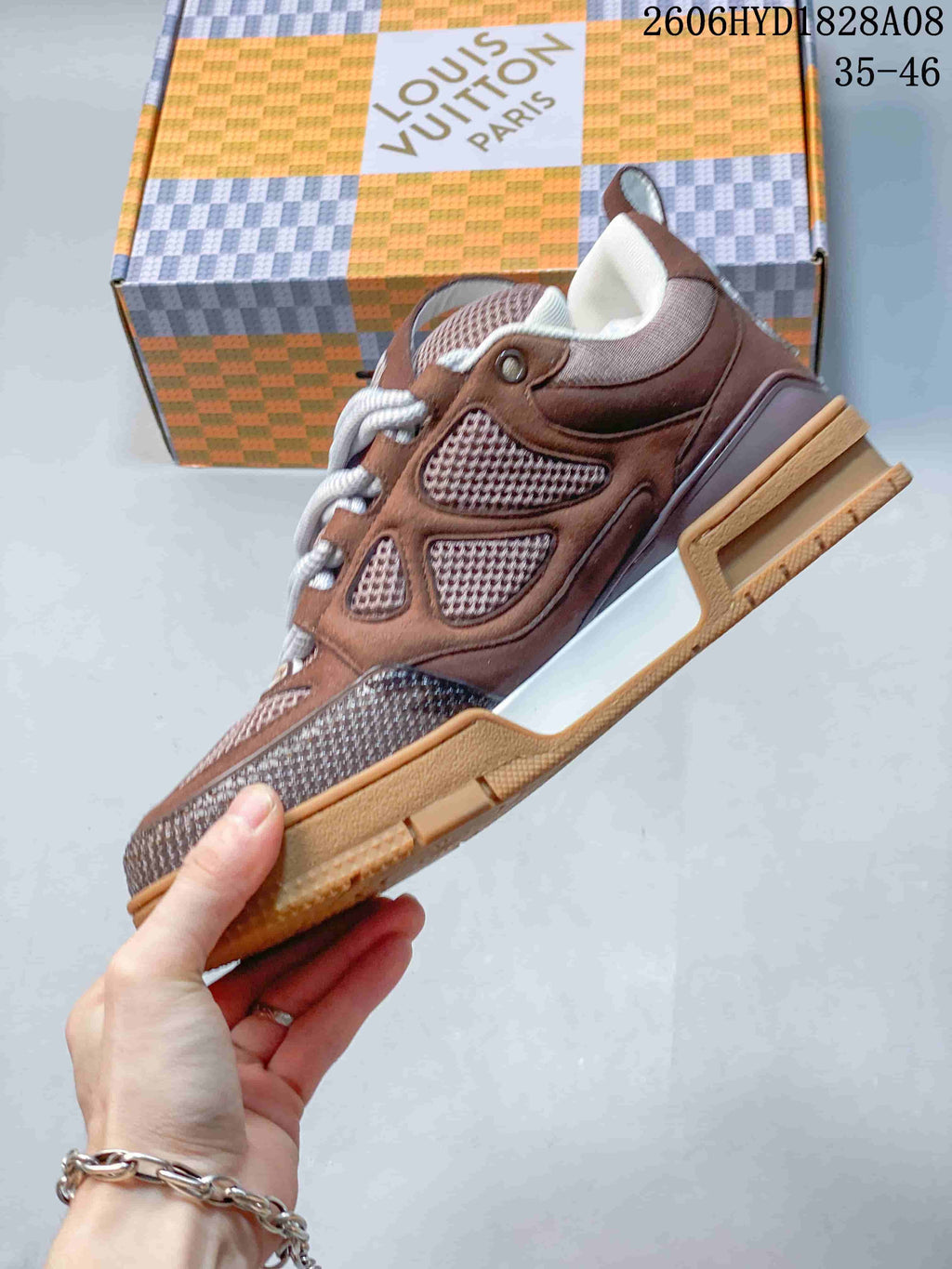 Side view of a brown Louis Vuitton Trainer sneaker with mesh panels and a white midsole accent
