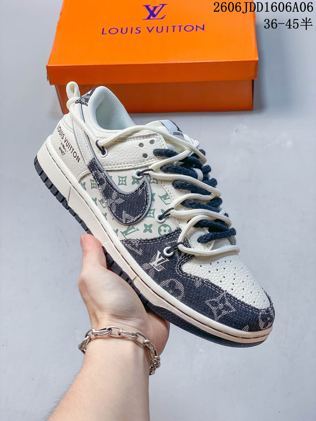 Angled side view of the cream and navy sneaker with patterned panels and contrasting Swoosh.