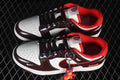 Pair of brown and white low-top sneakers with red accents and a hanging charm