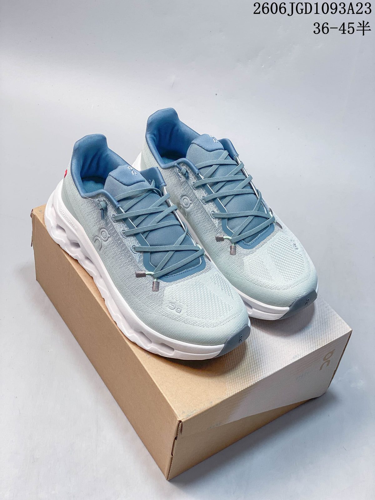 Pair of pale blue On Cloudtilt sneakers with white soles on a shoebox