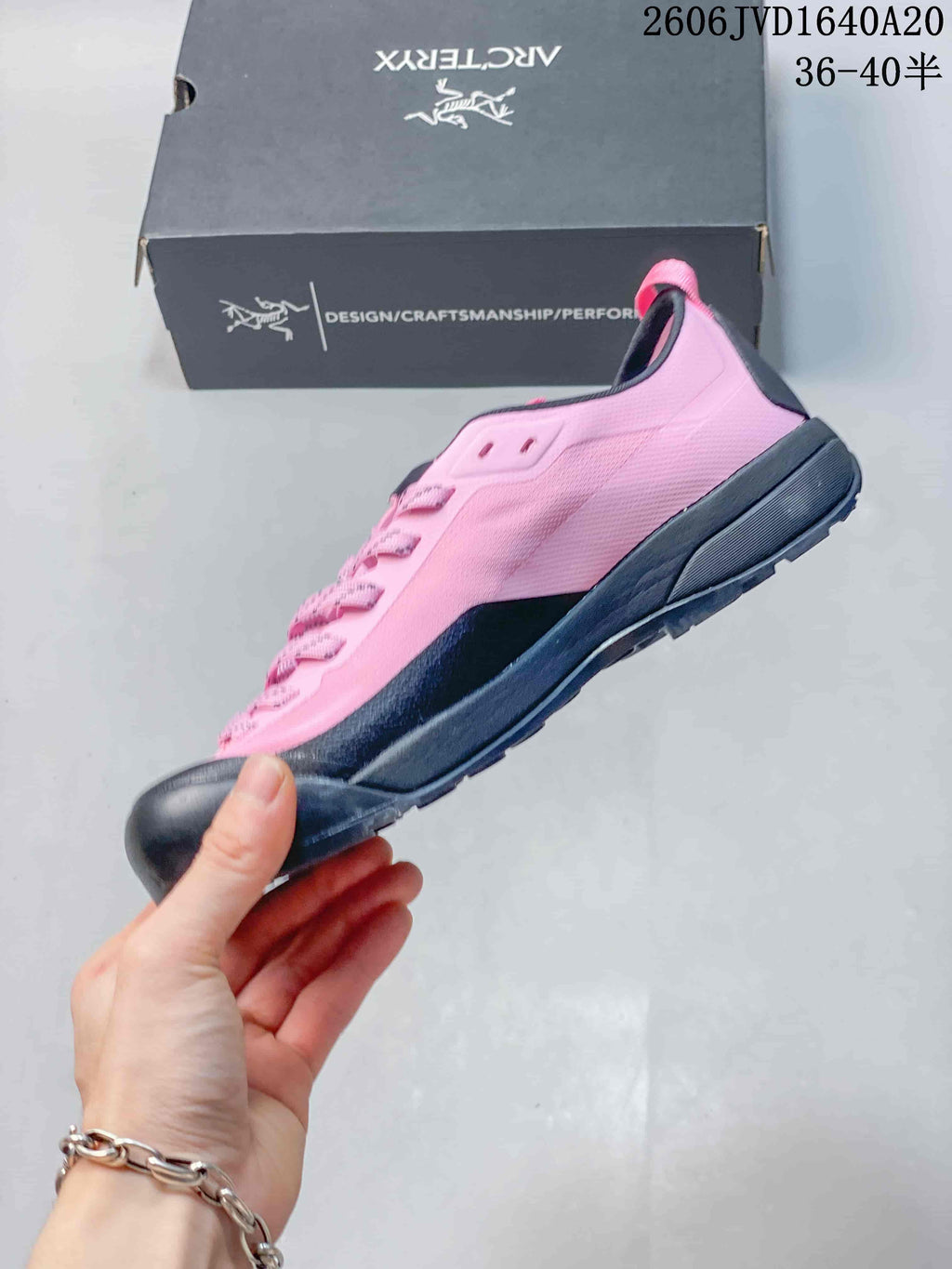 Side view of a pink low-cut trail shoe with dark gray trim