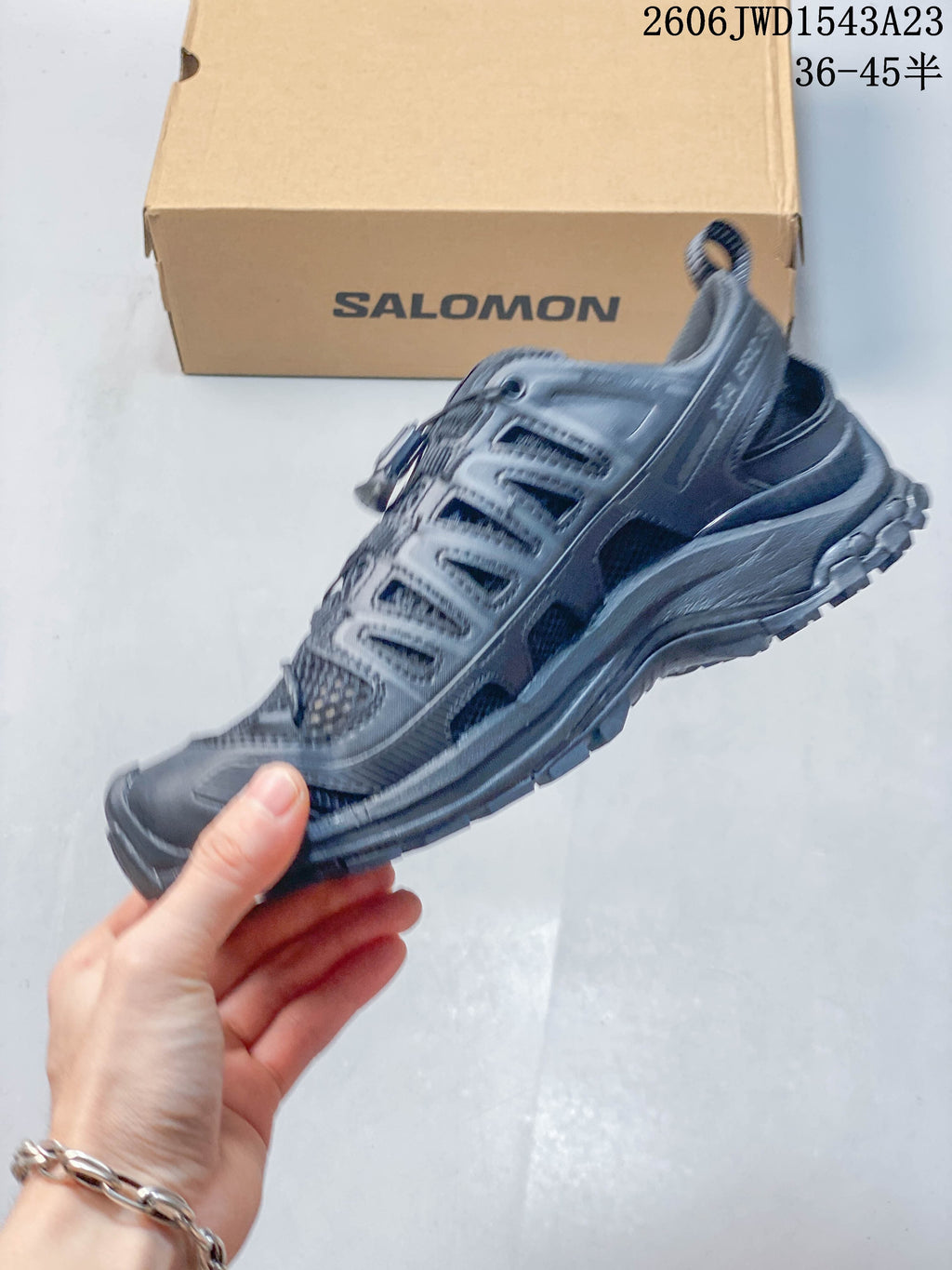 Side profile of a dark gray Salomon shoe with mesh panels and quick lacing.