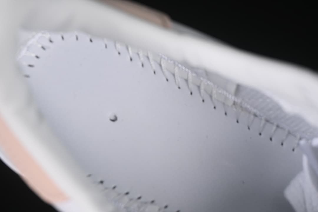 Close-up of stitching and interior construction of the white sneaker.