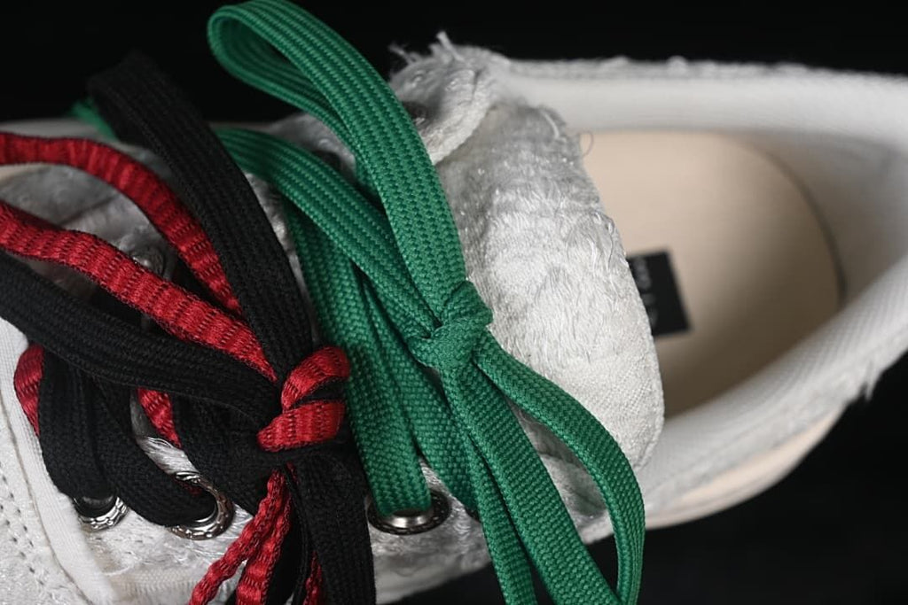 Close-up of green, black, and red alternate laces over the shoe.