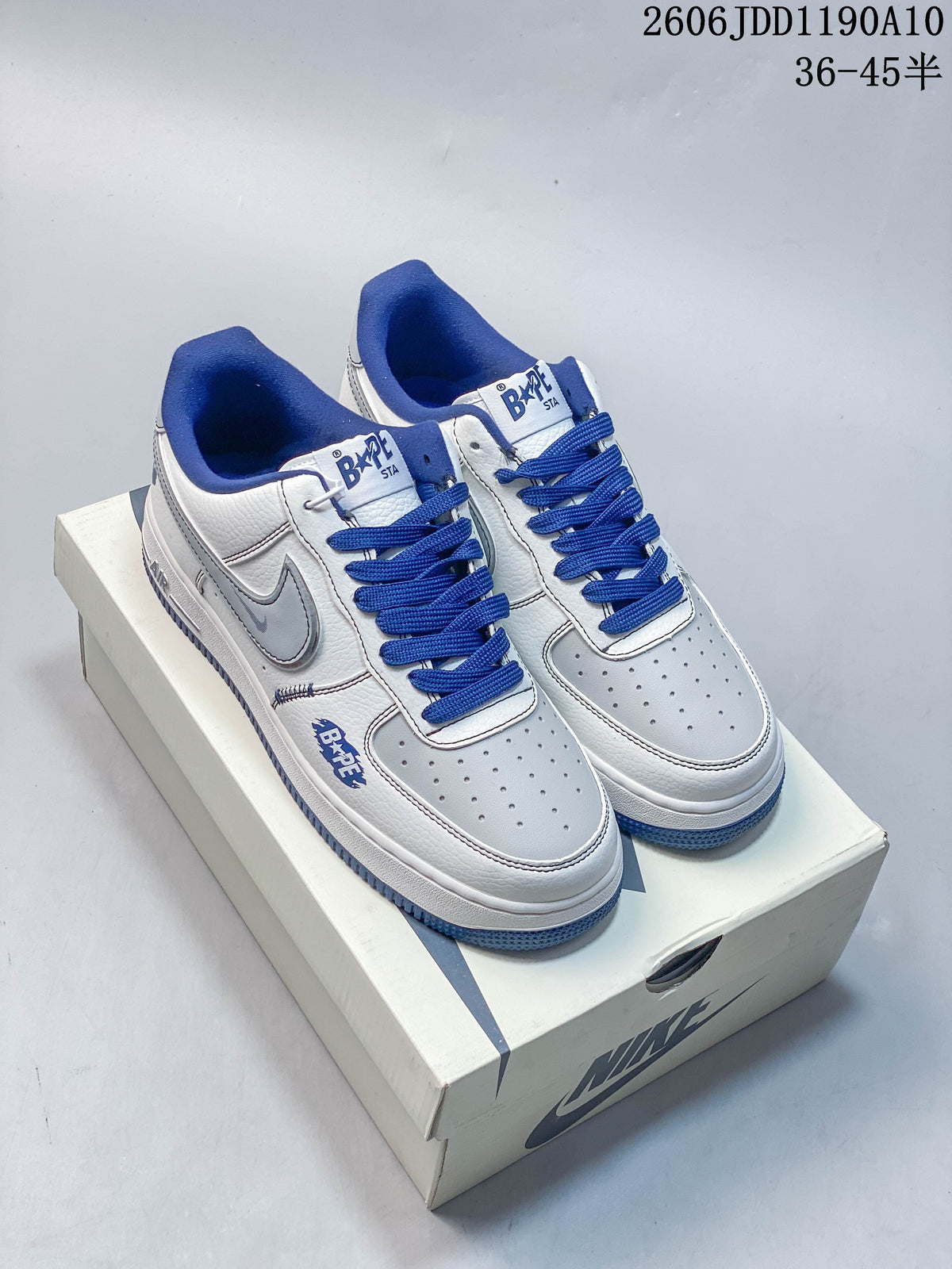 Pair of white and blue low-top sneakers shown on a shoebox