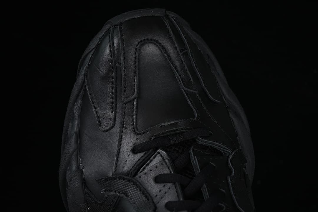 Top-down detail of the black sneaker toe and lace area
