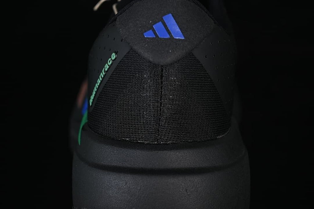 Rear view showing the shoe heel, Adidas mark, and green accent.