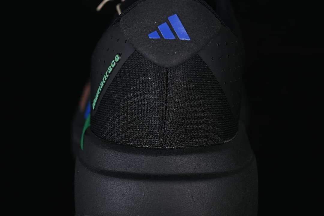 Rear view showing the shoe heel, Adidas mark, and green accent.