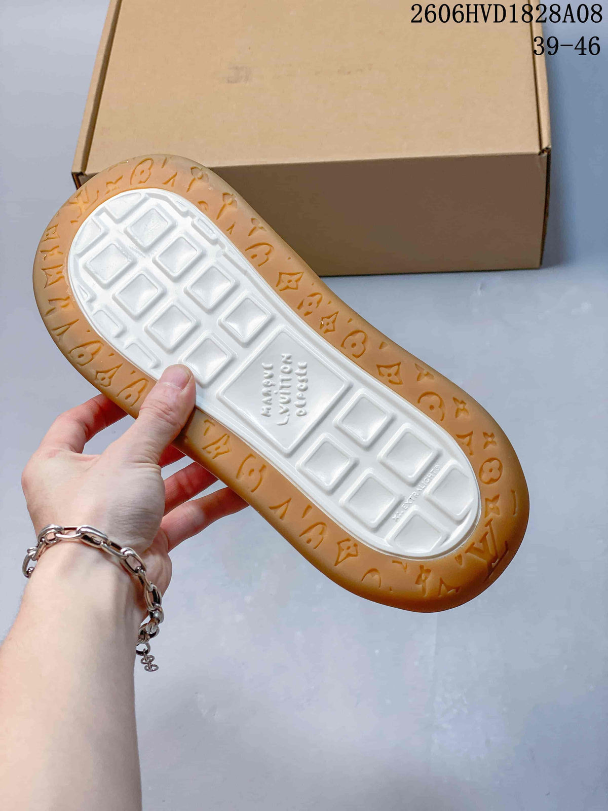 Underside of sneaker showing a white tread center and gum-colored patterned edge