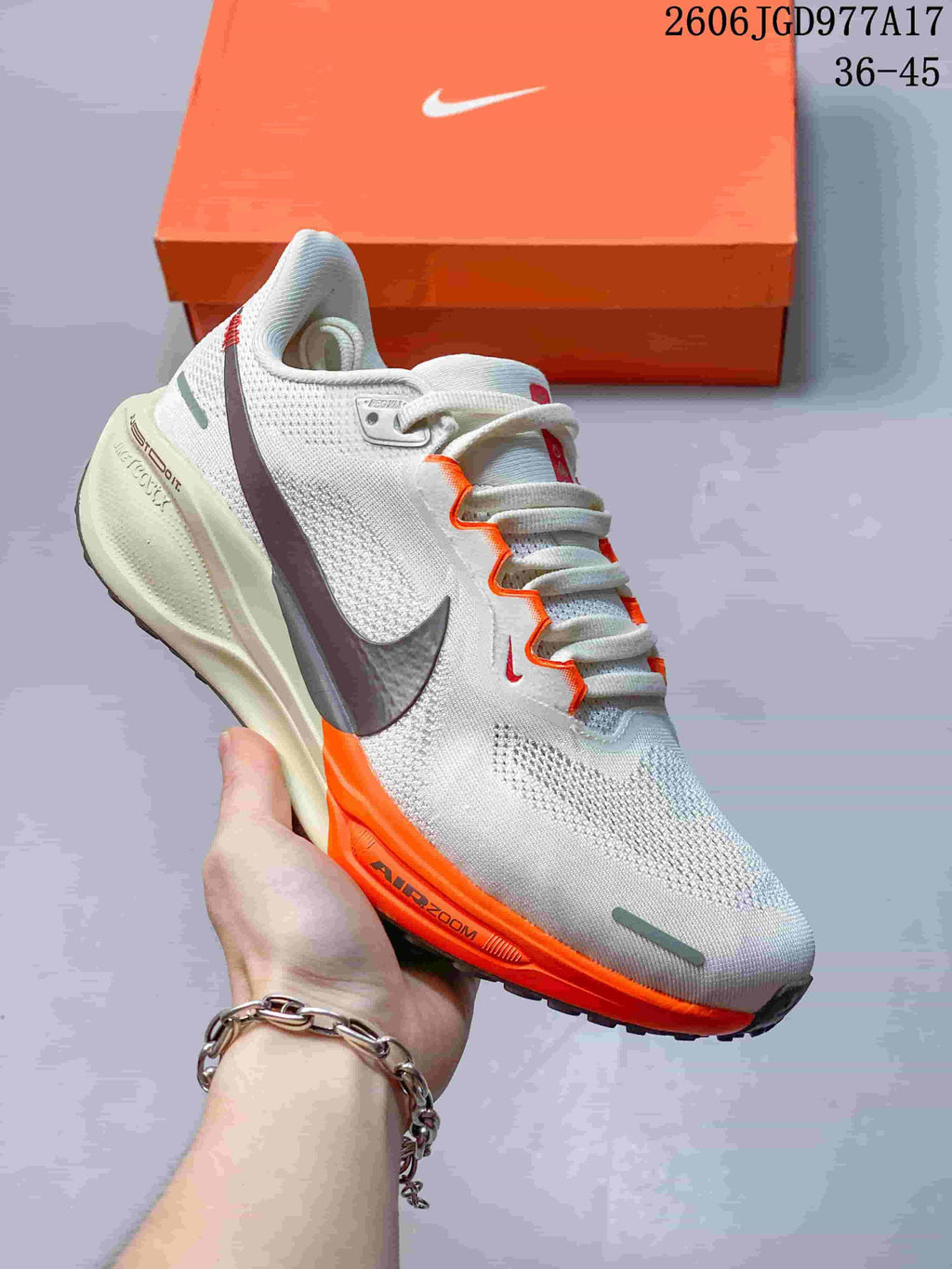 Side view of a light Pegasus 41 shoe with orange trim, dark Swoosh and Air Zoom midsole lettering