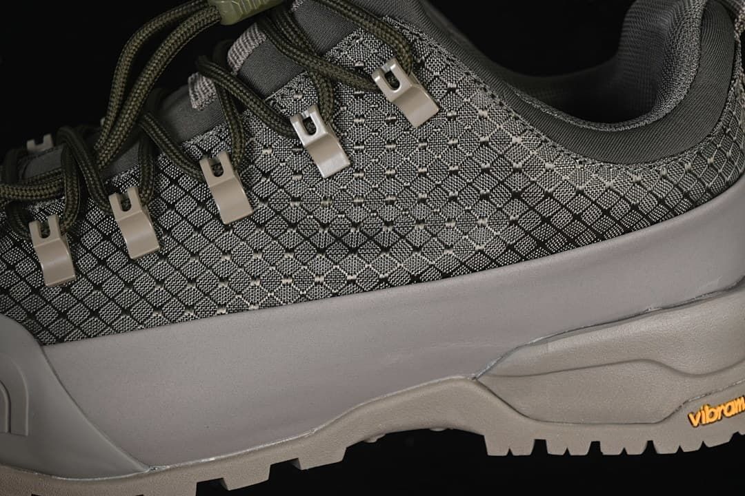 Close-up of the patterned upper, laces, and metal-tone lace loops