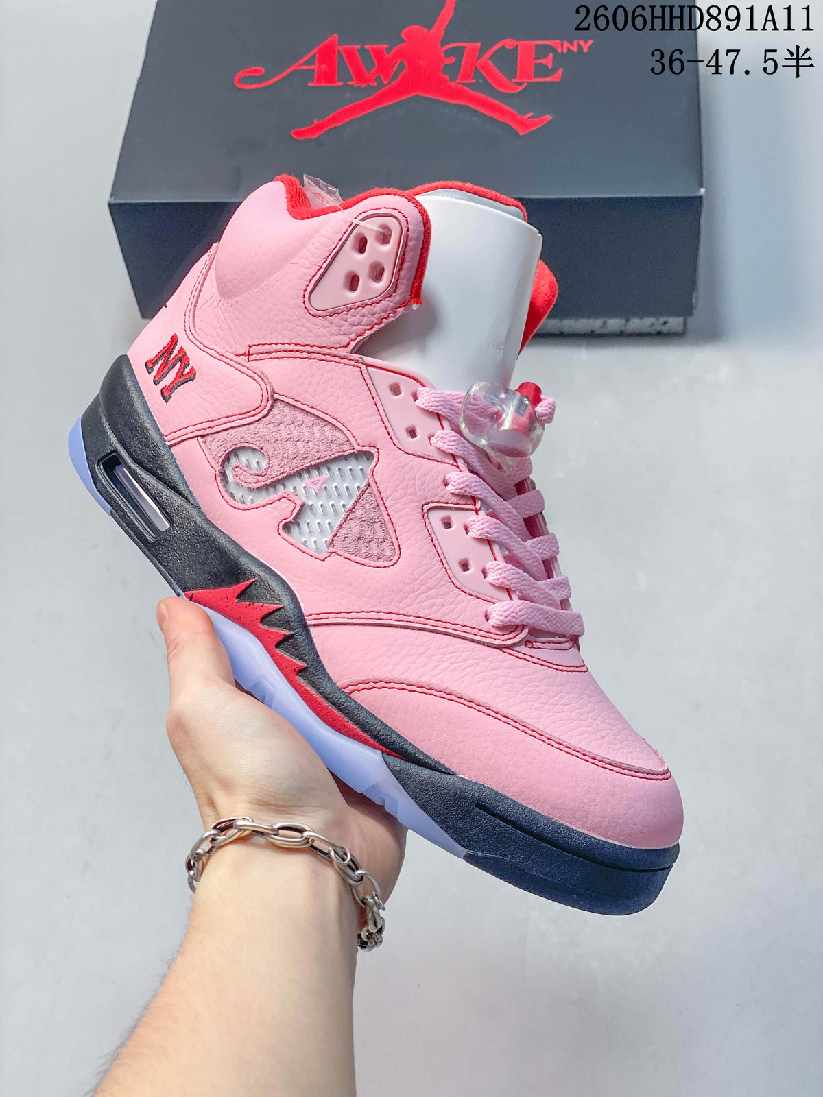 Angled side view highlighting the pink upper, side panel detailing, and navy and red accents.