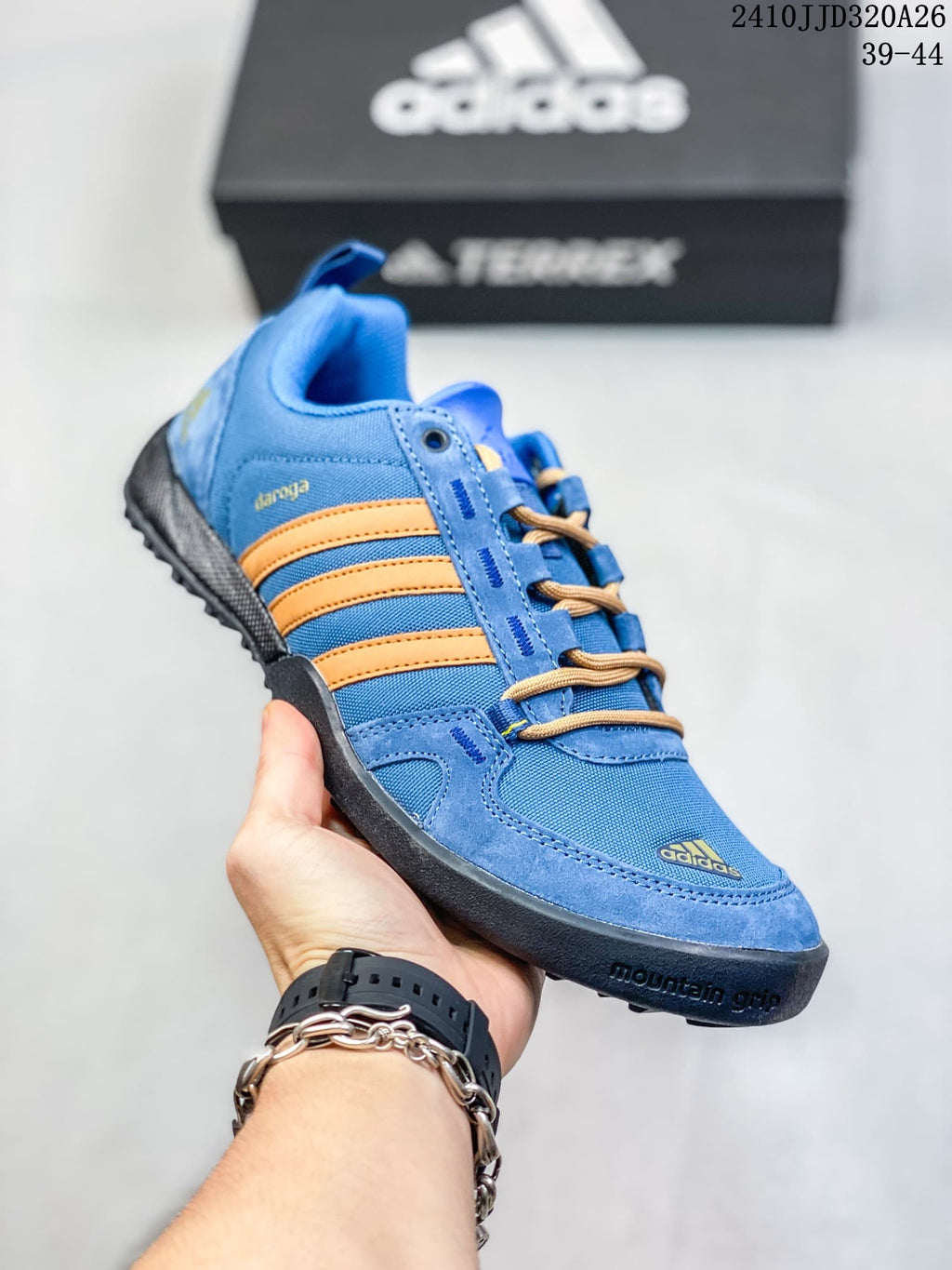 Angled side view of the blue adidas Daroga Plus shoe with orange stripes and a lugged outsole.