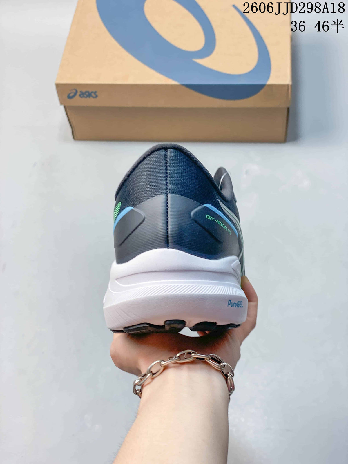 Rear view of a navy ASICS GT-1000 13 running shoe with a white midsole.