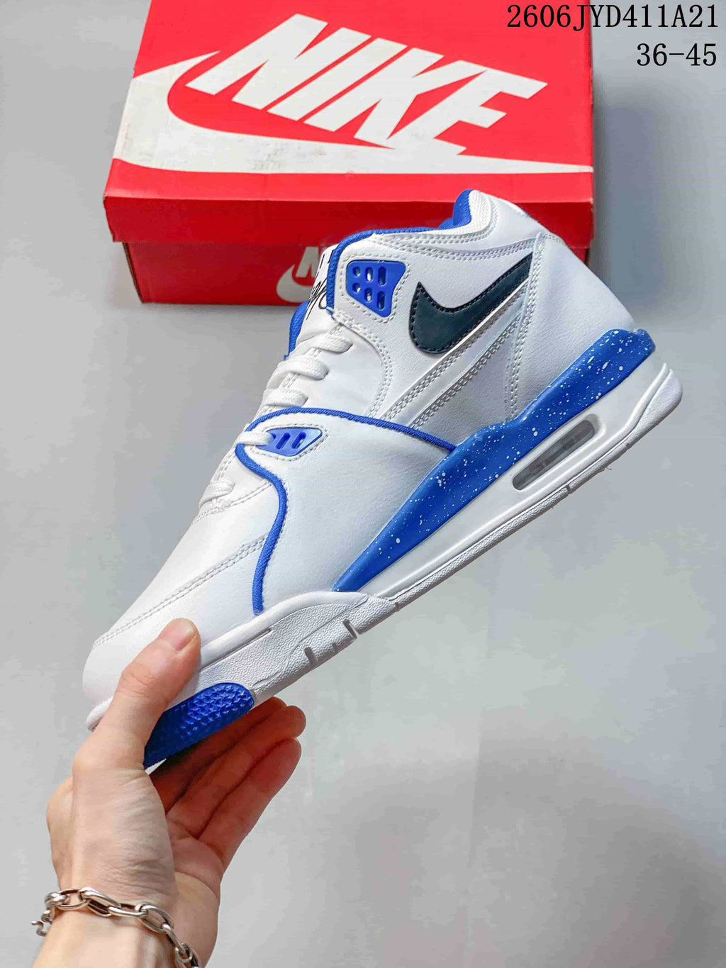 Side view of the white and blue mid-top shoe with black Swoosh