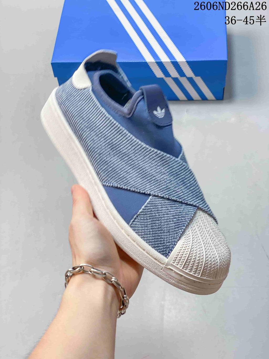 Angled view of a blue slip-on sneaker with a white shell-style toe cap and sole.