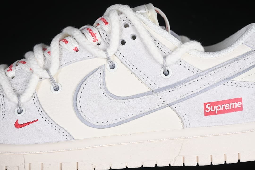 Close-up of the gray Swoosh, red Supreme logo, and branded laces