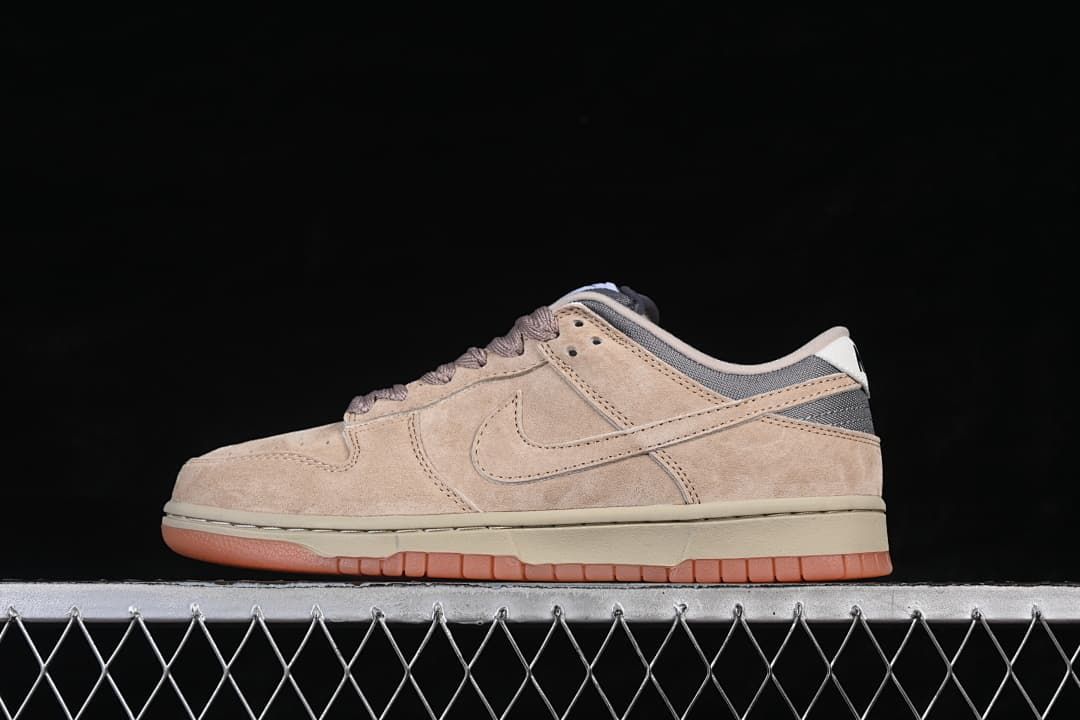 Side profile of a beige and grey Nike SB Dunk Low with brown laces and a gum-colored outsole