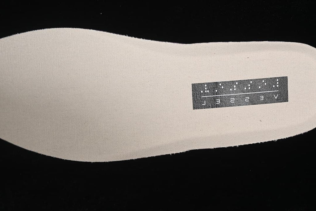Light-colored fabric insole with a black rectangular label.