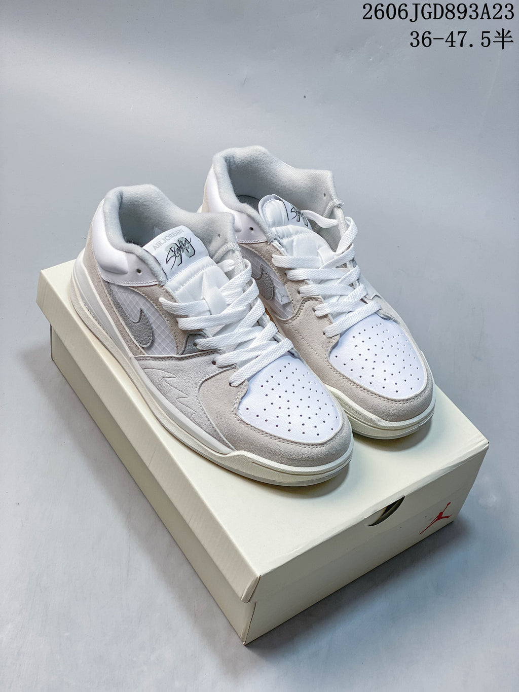 Pair of white and light grey Jordan Stadium 90 sneakers on a shoe box