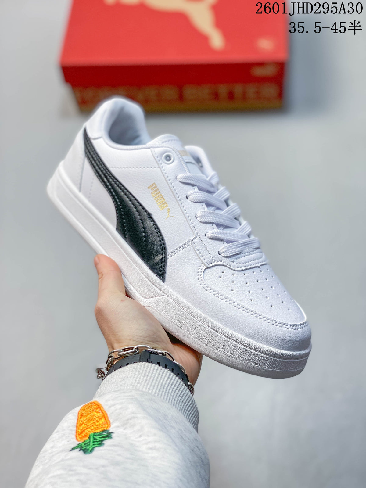 Angled side view of a white Puma Caven 2.0 sneaker with dark stripe and gold-tone detail