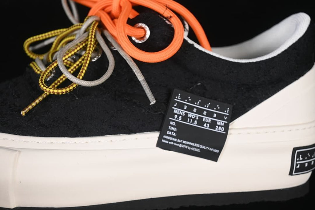 Side detail of the black upper, colorful laces and size tag