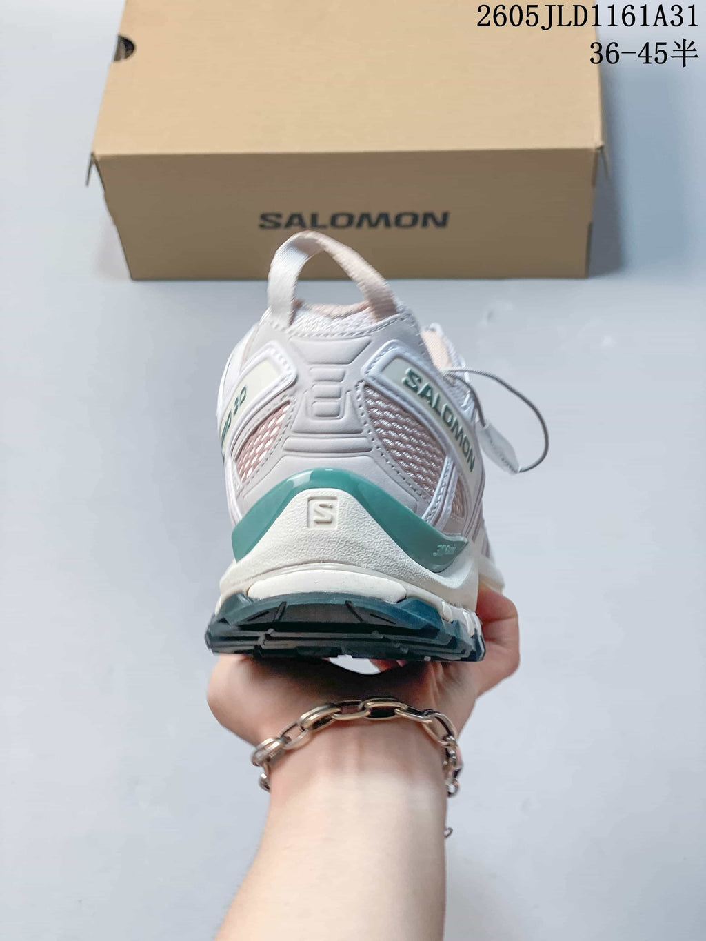 Rear view of a white Salomon XA Pro 3D sneaker with teal heel accents