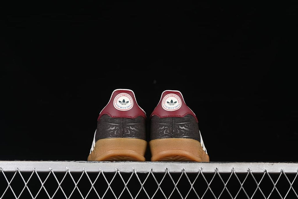 Rear view of both sneakers showing burgundy heel tabs and gum soles.