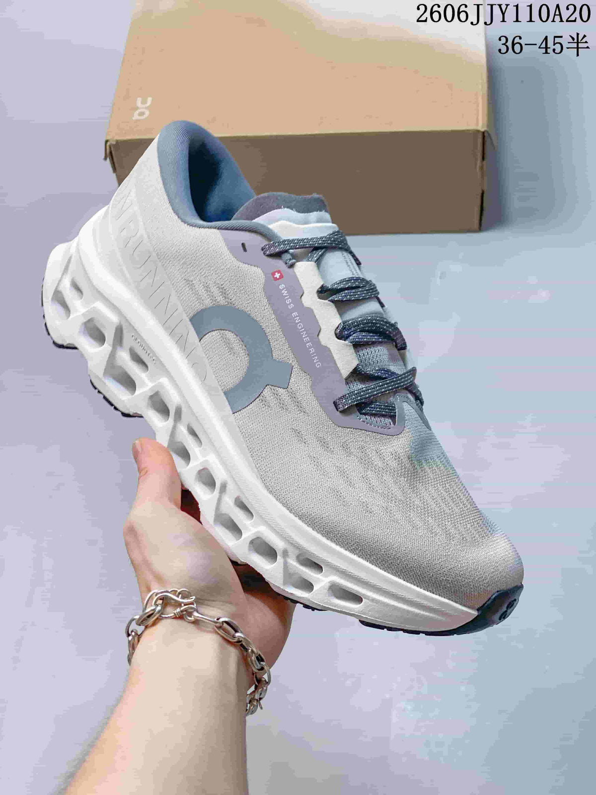 Angled side view showing the shoe's light gray upper, branding, laces, and sole