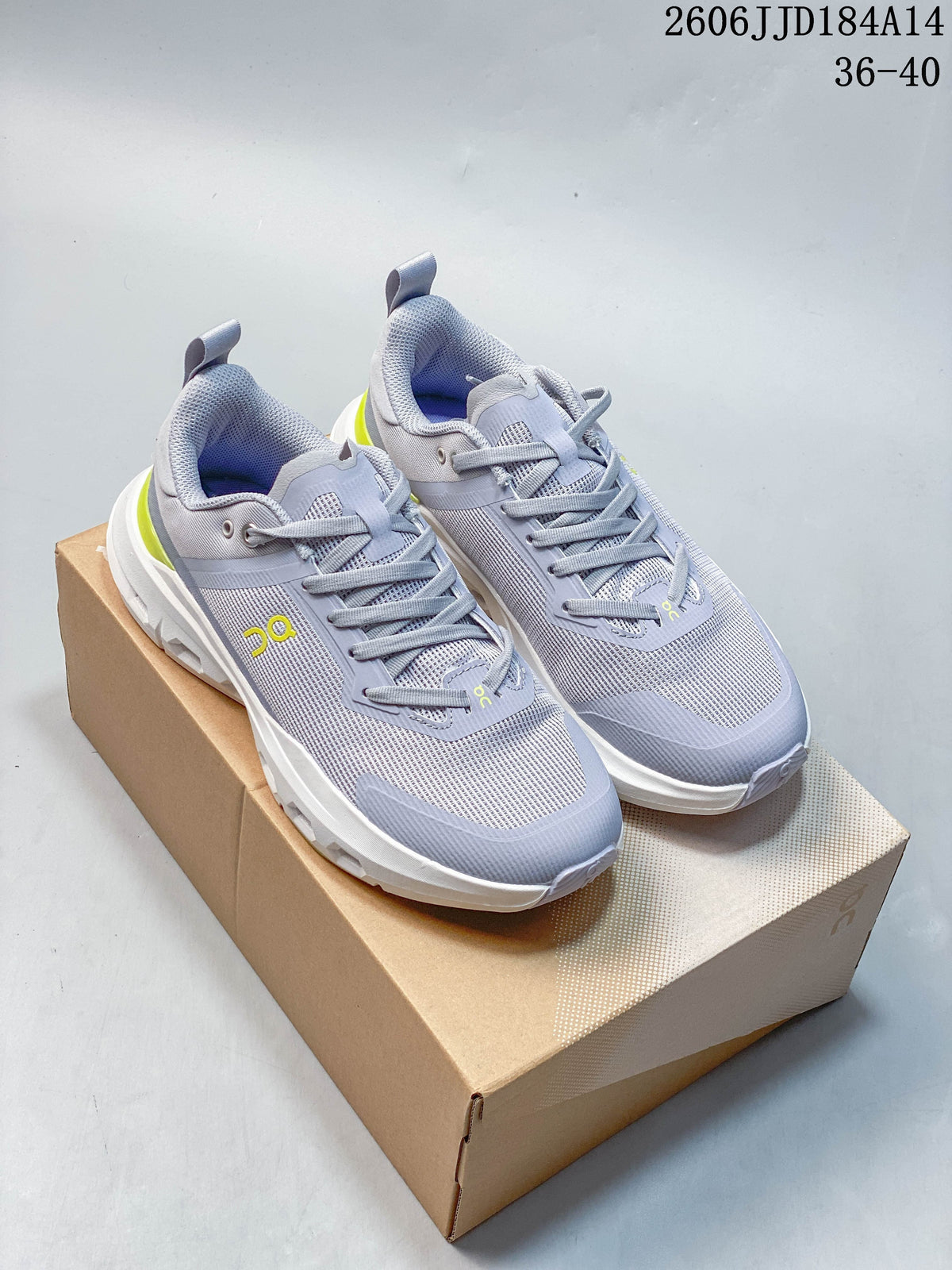 Pair of grey On Cloudpulse Next women's running shoes with yellow accents, shown on a shoebox.