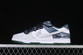 Side view of white, blue-gray, and dark green Nike SB Dunk Low sneakers with black laces and graphic side detailing