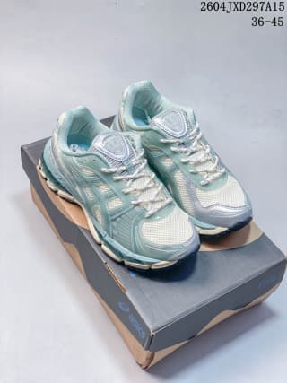 Pair of light sage and off-white ASICS sneakers displayed on a shoebox, with the style code and size range visible above.