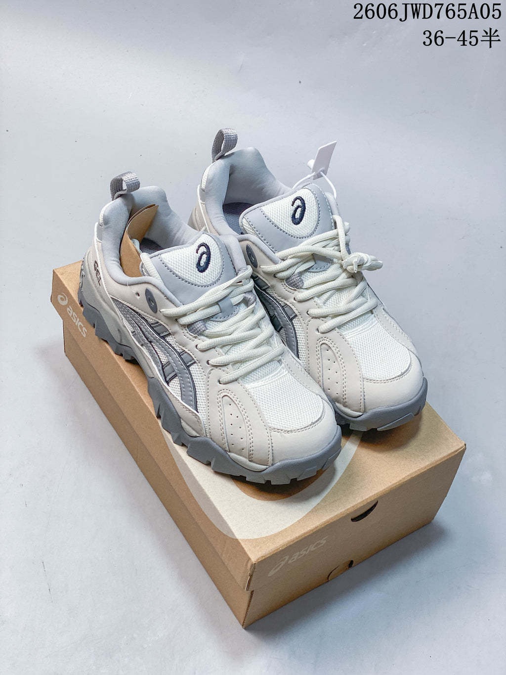 Pair of light white and grey ASICS Gel-TRUCK sneakers displayed on a shoebox