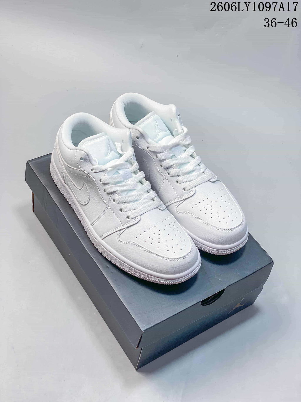 Pair of white Jordan Air Jordan 1 Low sneakers on a dark shoebox