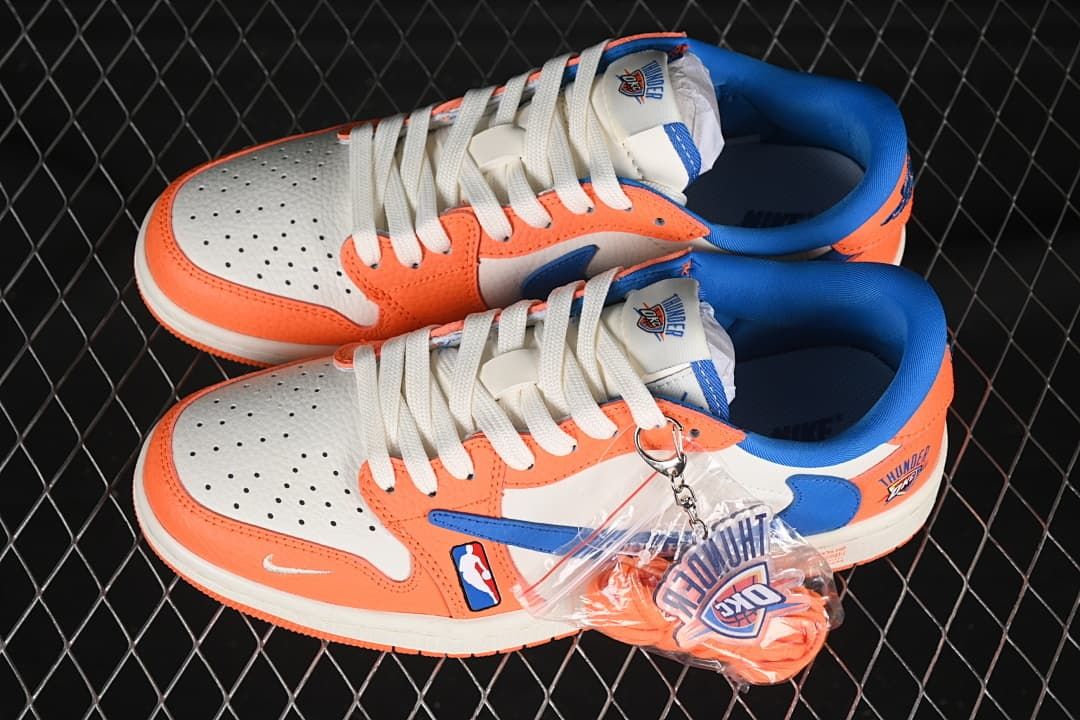 Top view of a pair of orange, white, and blue Thunder-themed low-top sneakers with a team-logo accessory