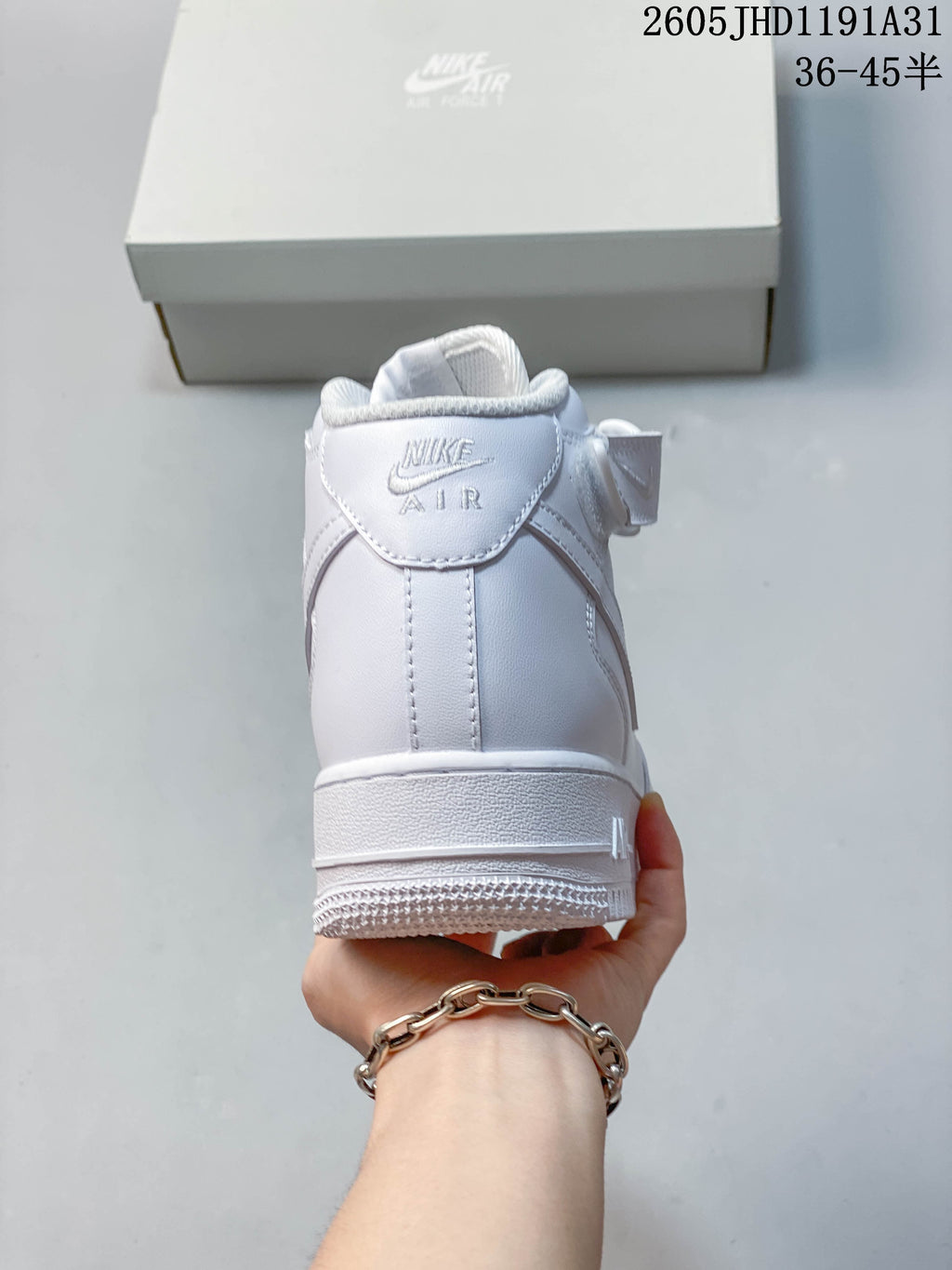 Rear view of a white high-top sneaker showing the heel and ankle strap