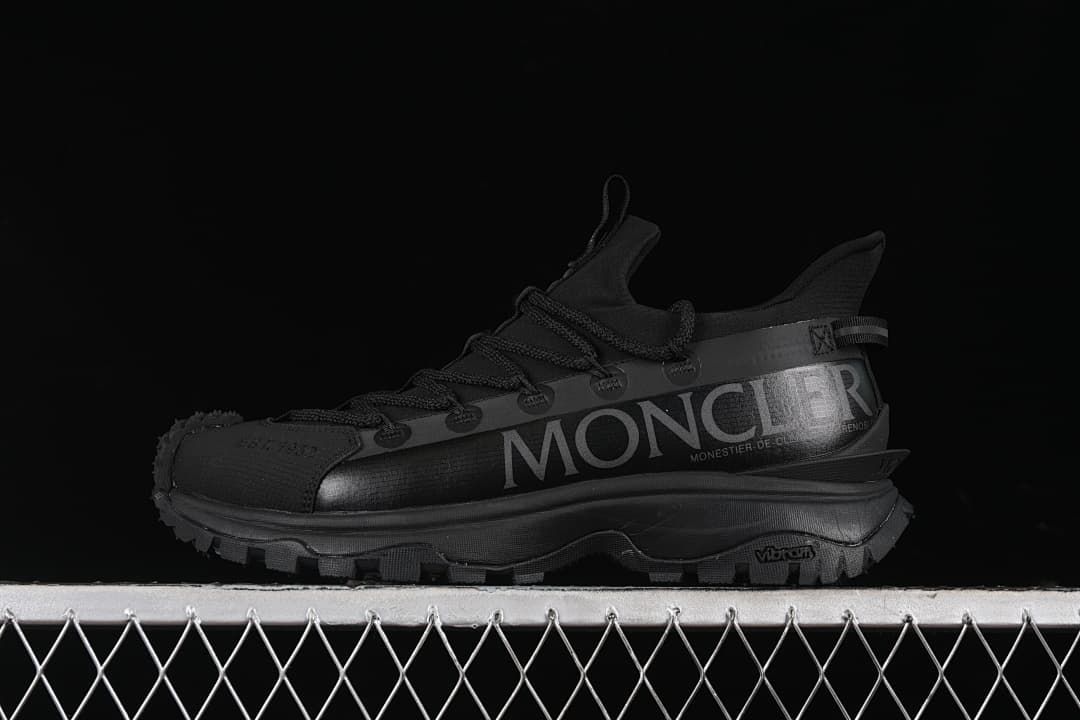 Side view of a black Moncler Trailgrip Lite 2 outdoor sneaker