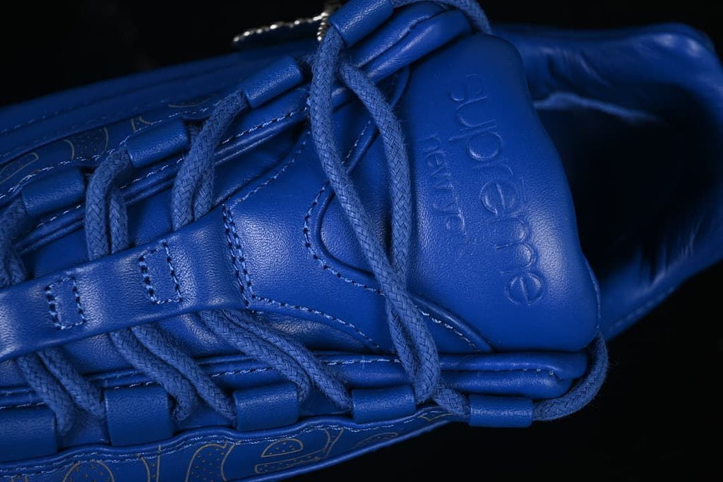 Close-up of the laces, lace loops, and embossed Supreme tongue branding.