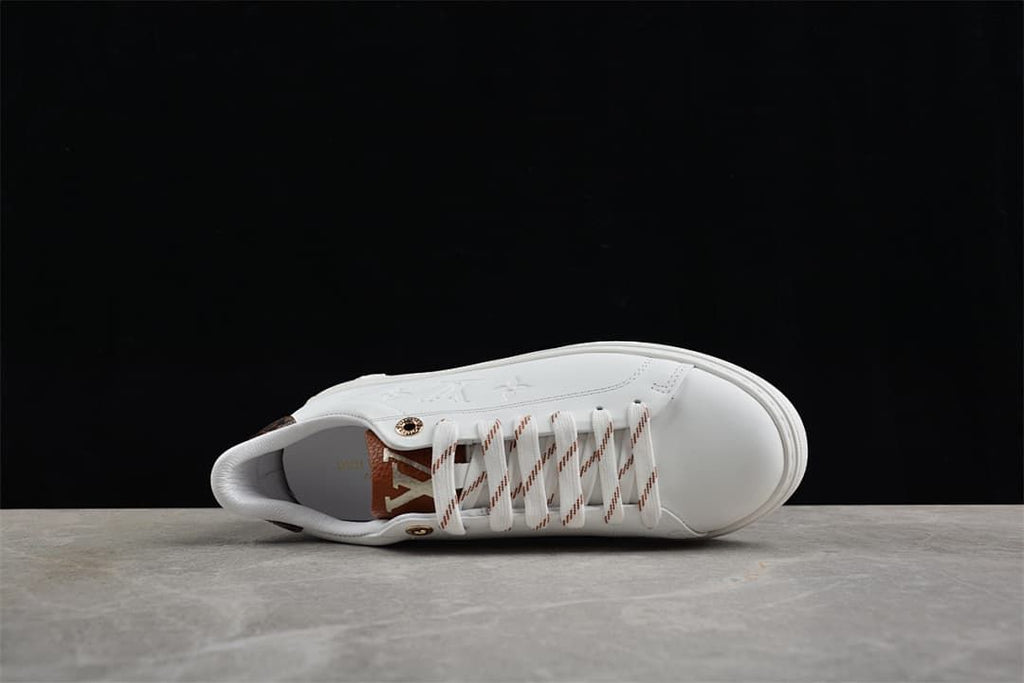 Top view of white sneaker with striped laces and embossed side details