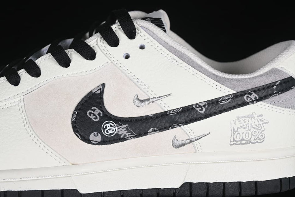 Close-up of patterned black Swoosh and small side logos on the gray and white upper
