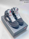 Pair of dark Jordan Air Jordan 5 high-top sneakers on a shoe box, shown from the front and side.