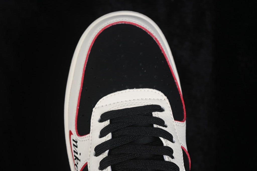 Close-up of the black perforated toe box, white overlay and red accent trim.