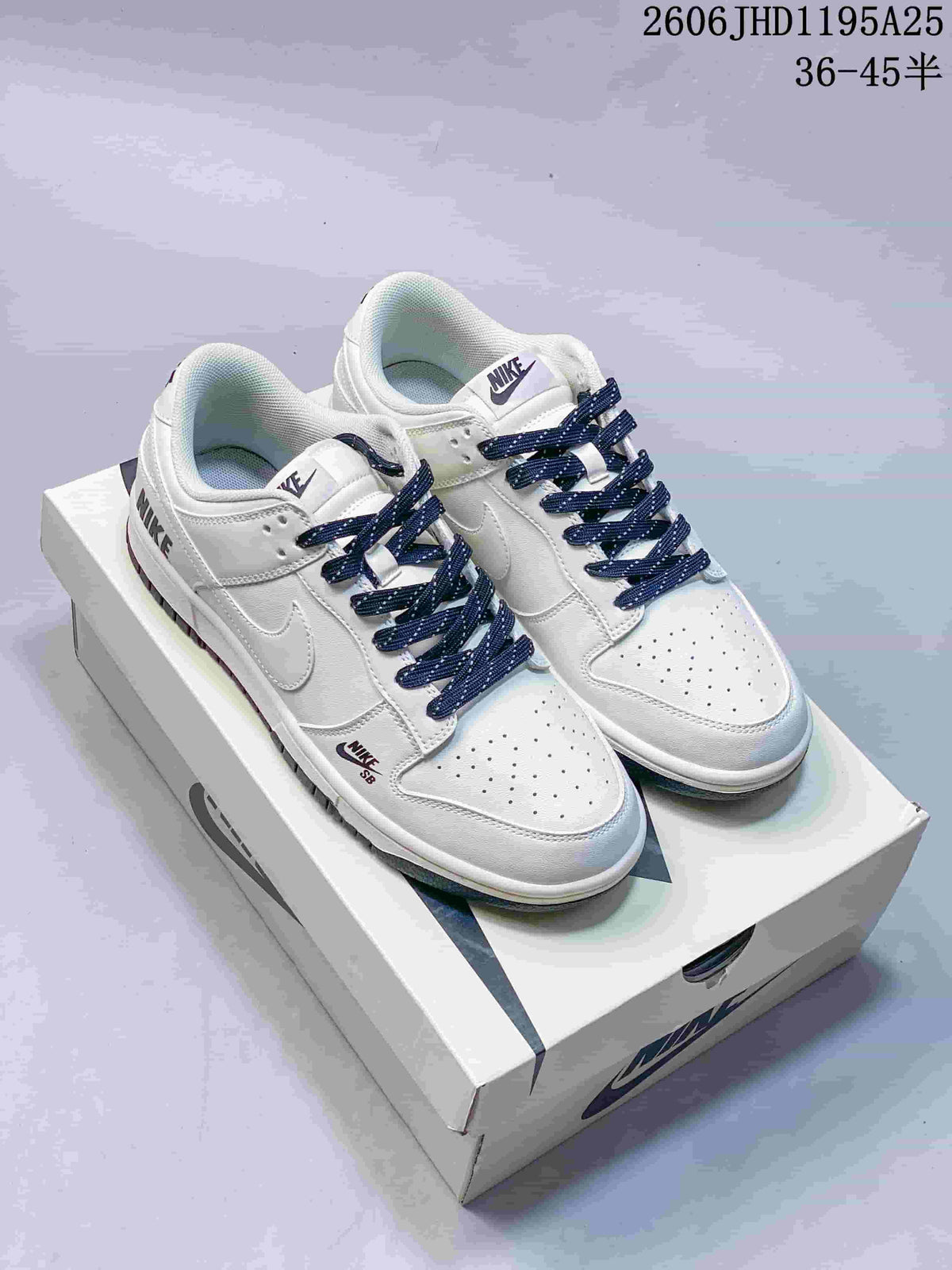 Pair of white low-top sneakers with navy laces and dark outsole accents