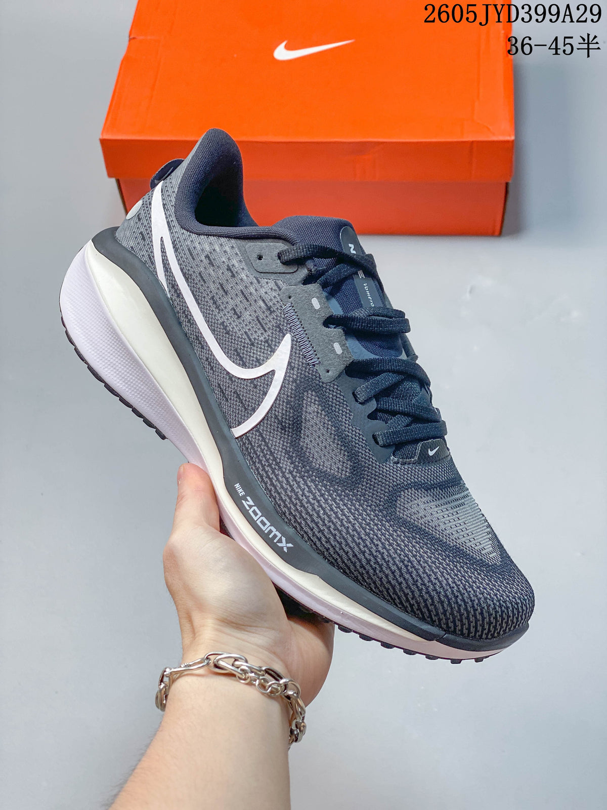 Dark gray Nike Air Zoom Vomero 17 running shoe with white swoosh and white sole.